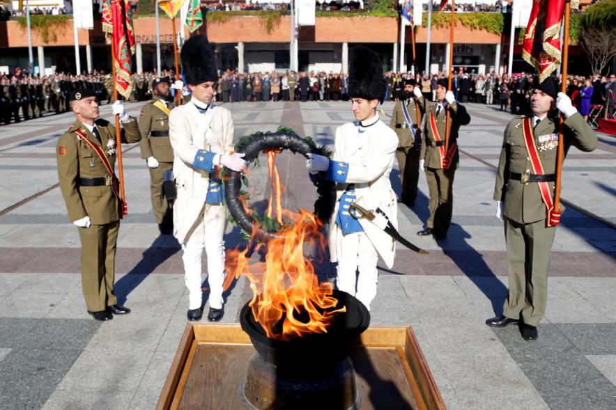 Militares con uniforme napoleónico honrando con corona de laureles la llama de la democracia