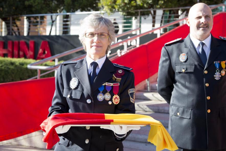 Detalle mando policial haciendo entrega de la bandera para ser izada