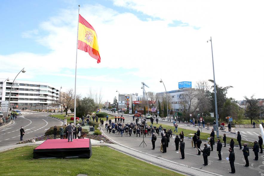 Banda y asistentes con bandera en lo alto