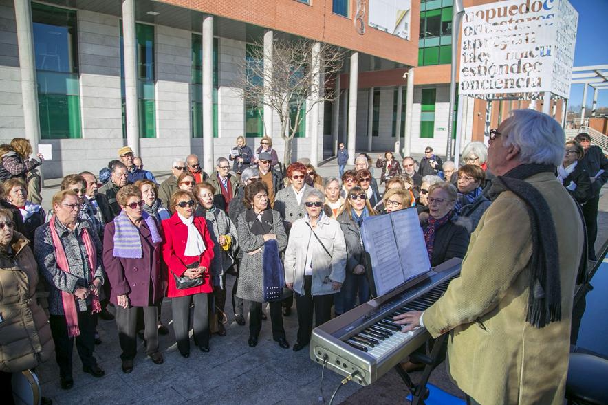 Cantando Juntos - Coral de Mayores en la Plaza Mayor -  Grupo de mayores  junto  al pianista.
