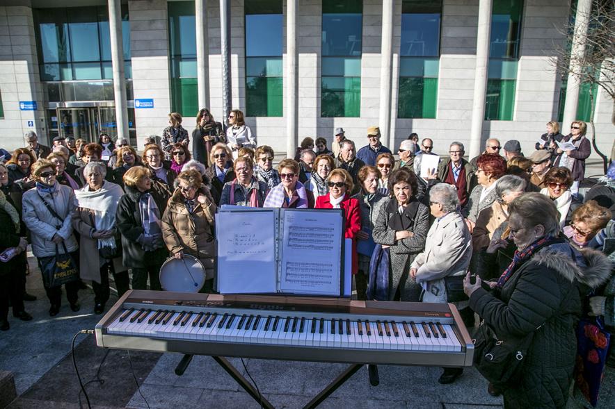 Cantando Juntos - Coral de Mayores en la Plaza Mayor - Primer plano del grupo de mayores y el piano.