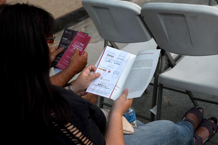 Opera en la Calle - Imagen de una persona leyendo unos programas.