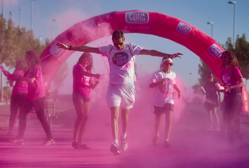 Carrera Color Run - Imagen participantes en la carrera con nubes de polvo de color rosa.