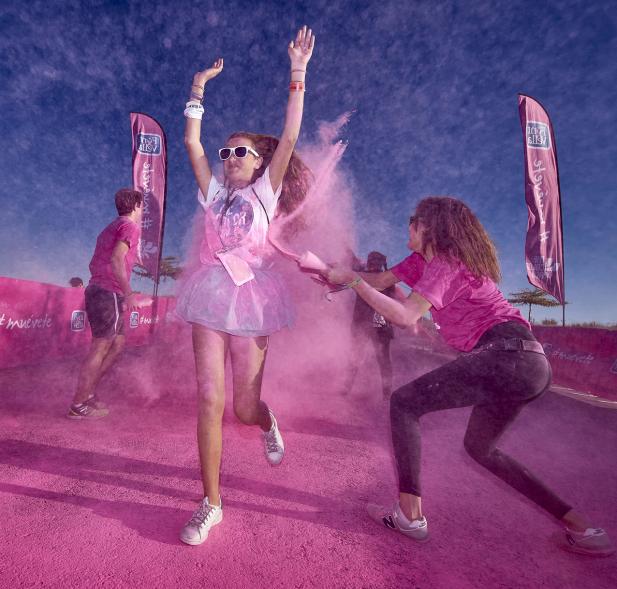 Carrera Color Run - Imagen participantes en la carrera con nubes de polvo de color rosa.