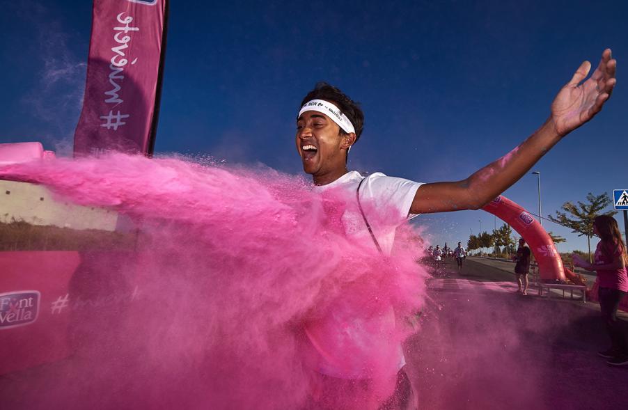 Carrera Color Run - Imagen participante en la carrera con nubes de polvo de color rosa.