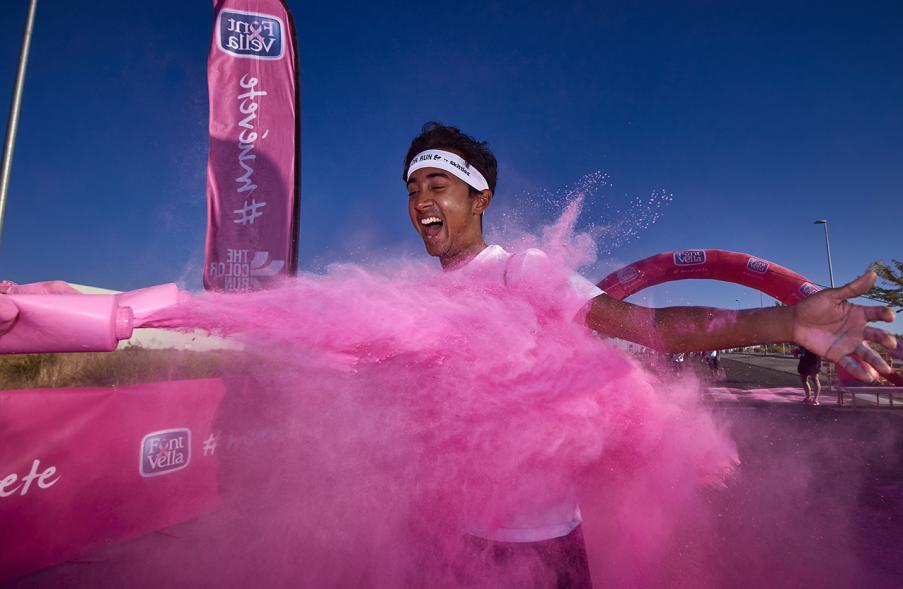 Carrera Color Run - Imagen participante en la carrera con nubes de polvo de color rosa.