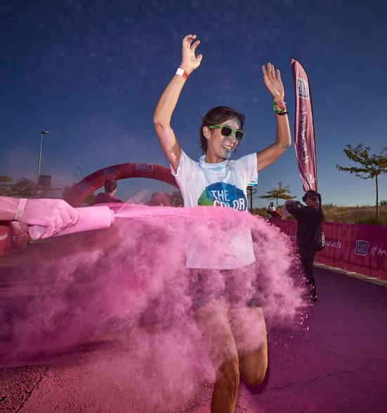 Carrera Color Run - Imagen participante en la carrera con nubes de polvo de color rosa.