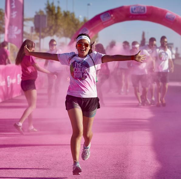 Carrera Color Run - Imagen participante en la carrera con nubes de polvo de color rosa