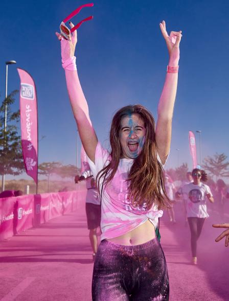 Carrera Color Run - Imagen participante en la carrera con nubes de polvo de color rosa.