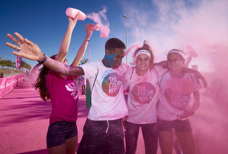 Carrera Color Run - Imagen participantes en la carrera con nubes de polvo de color rosa.