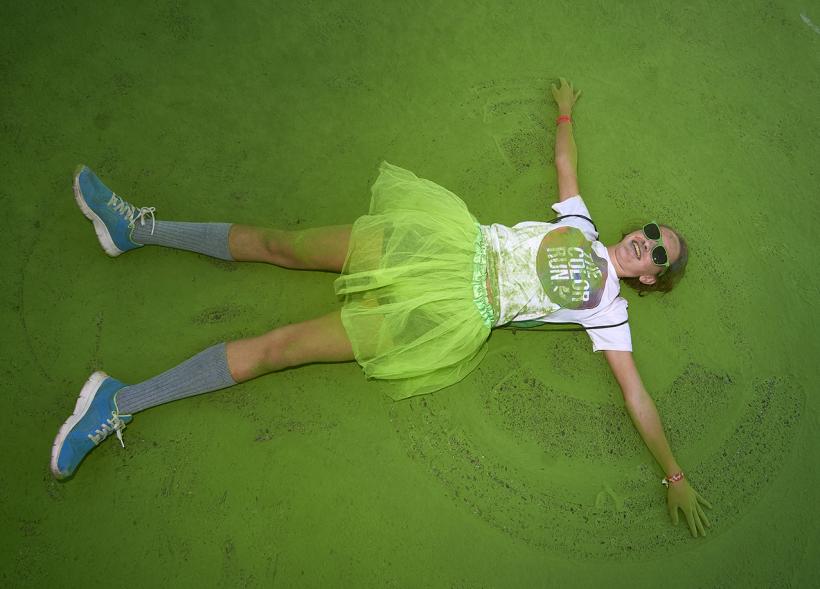 Carrera Color Run - Imagen participante en la carrera con nubes de polvo de color verde.