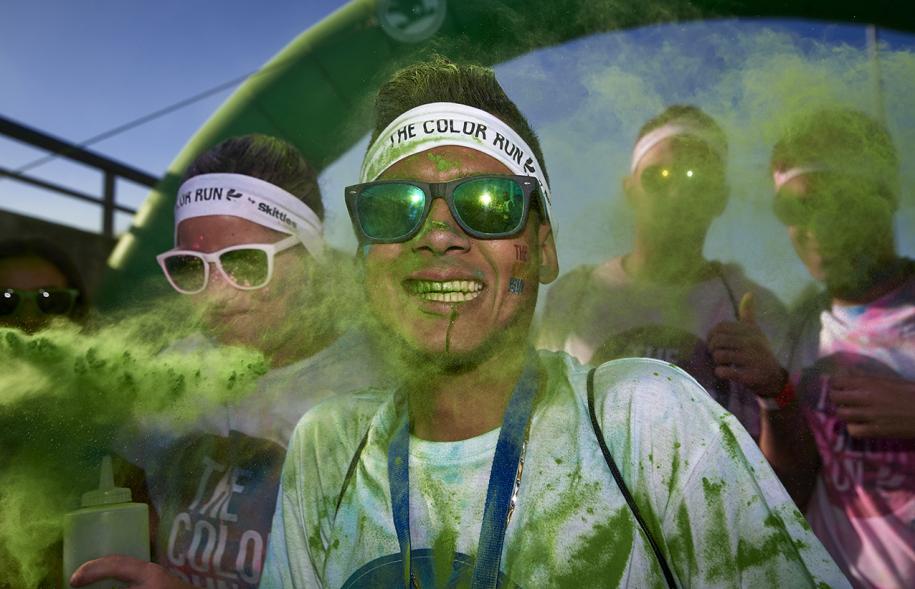 Carrera Color Run - Imagen participante en la carrera con nubes de polvo de color verde.