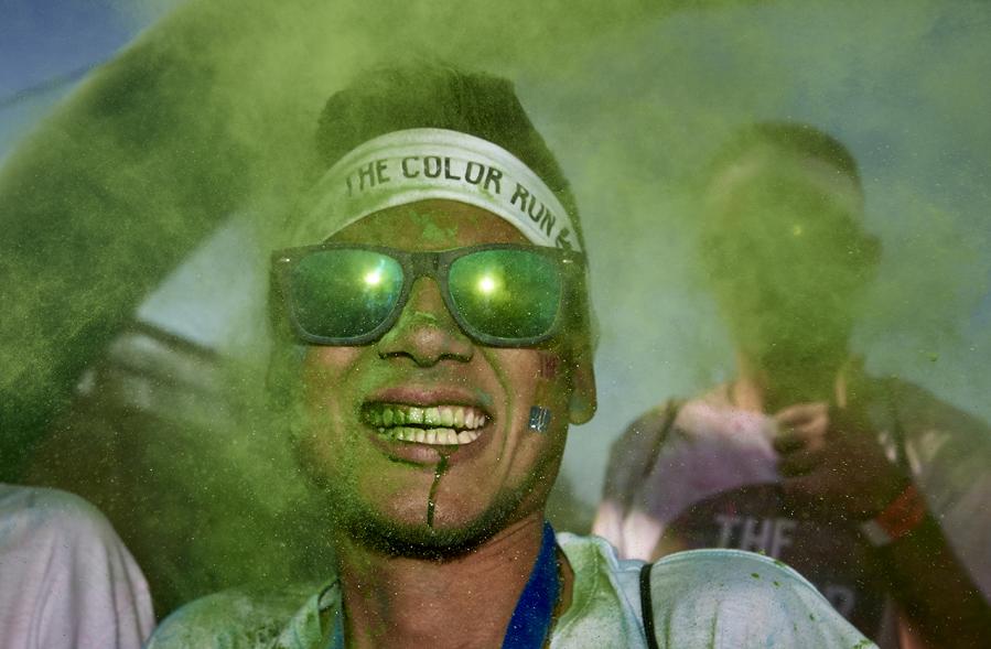 Carrera Color Run - Imagen participante en la carrera con nubes de polvo de color verde.