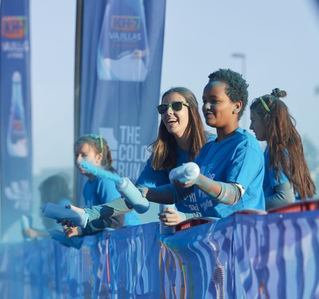 Carrera Color Run - Imagen participantes en la carrera con nubes de polvo de color azul.