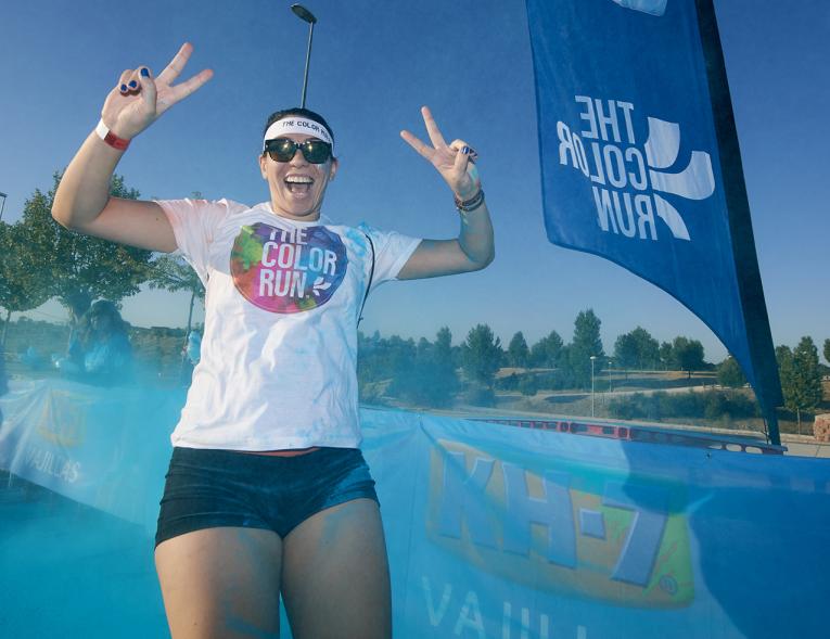 Carrera Color Run - Imagen participante en la carrera con nubes de polvo de color azul.