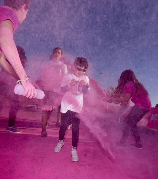 Carrera Color Run - Imagen participantes en la carrera con nubes de polvo de color rosa.