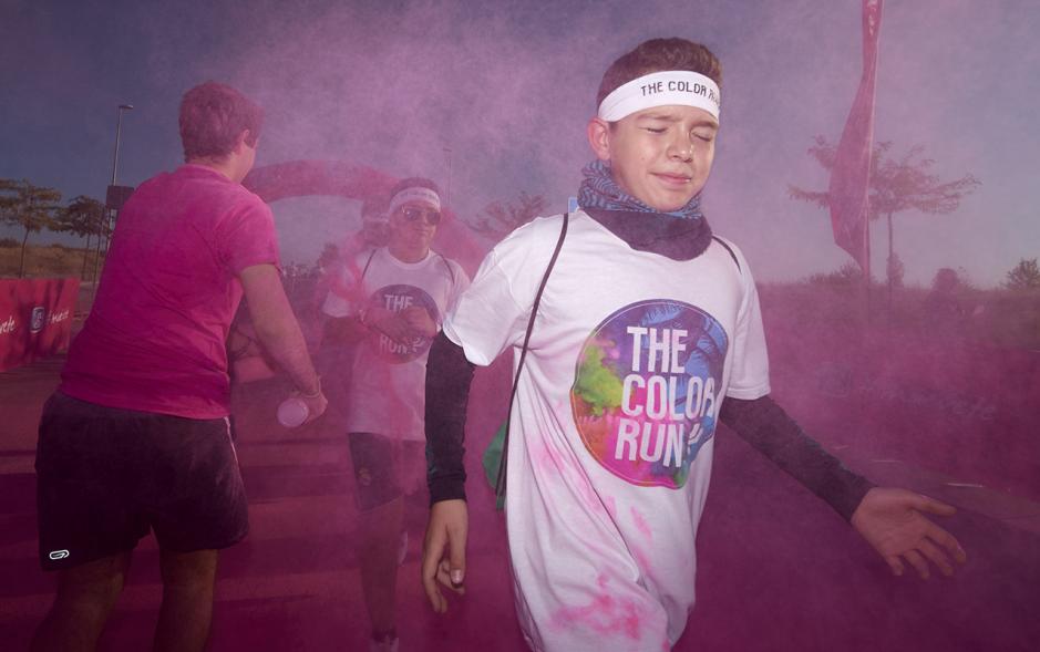 Carrera Color Run - Imagen participante en la carrera con nubes de polvo de color rosa.