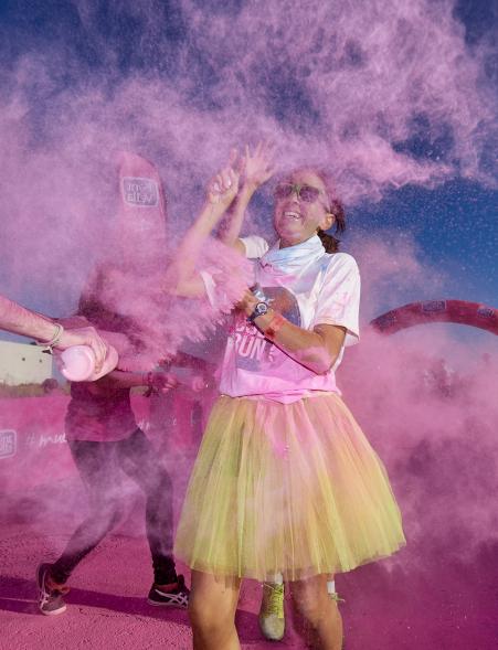 Carrera Color Run - Imagen participante en la carrera con nubes de polvo de color rosa.
