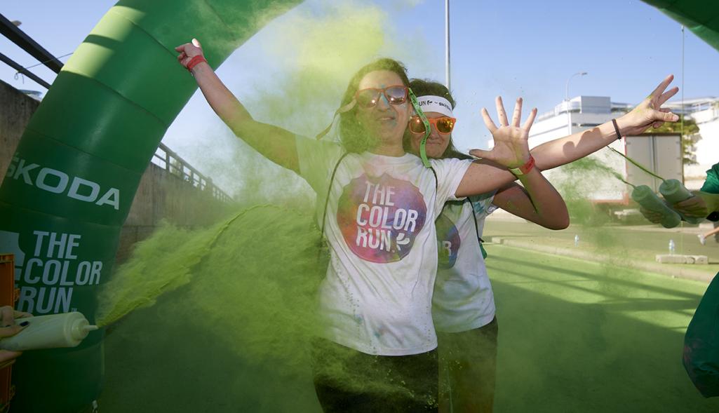 Carrera Color Run - Imagen participante en la carrera con nubes de polvo de color verde.