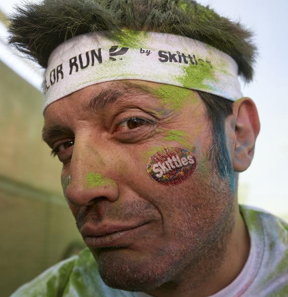 Carrera Color Run - Imagen participante en la carrera con nubes de polvo de color verde.