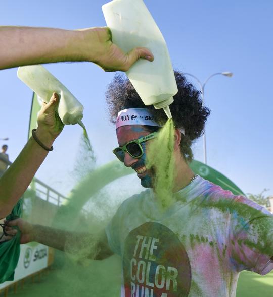 Carrera Color Run - Imagen de participantes en la carrera después de recibir polvo de color verde.