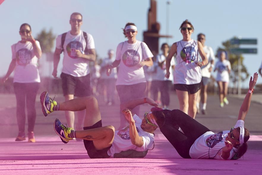 Carrera Color Run - Imagen participantes en la carrera con nubes de polvo de color rosa.