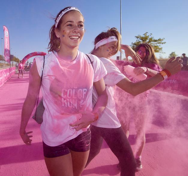 Carrera Color Run - Imagen participantes en la carrera con nubes de polvo de color rosa.
