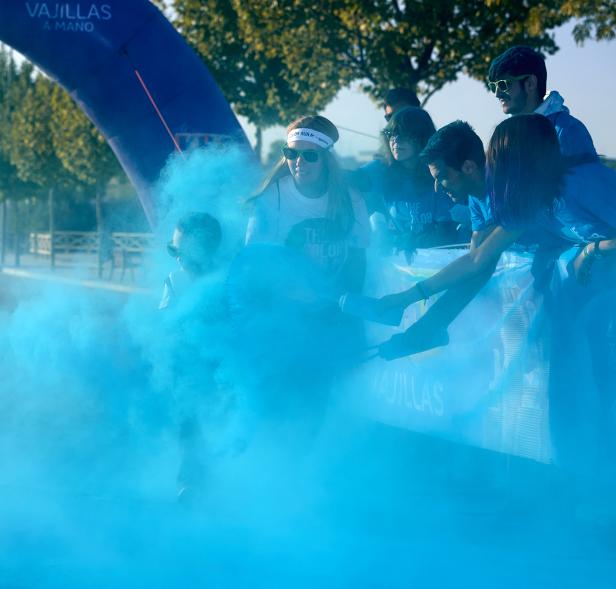 Carrera Color Run - Imagen participantes en la carrera con nubes de polvo de color azul.