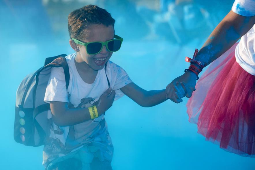 Carrera Color Run - Imagen participantes en la carrera con nubes de polvo de color azul.