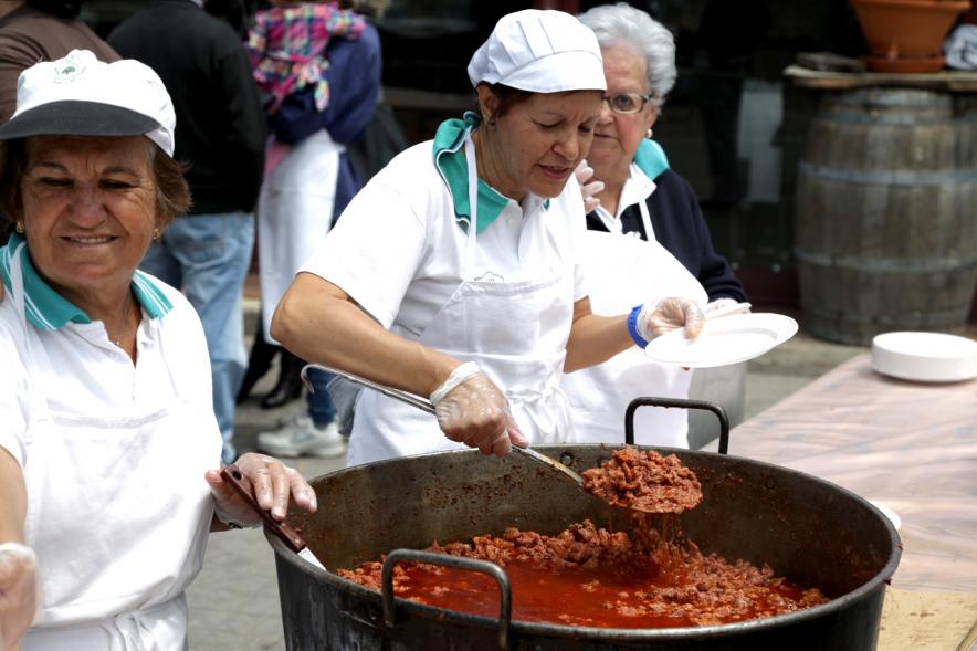 Mujeres reparten picadillo de cerdo