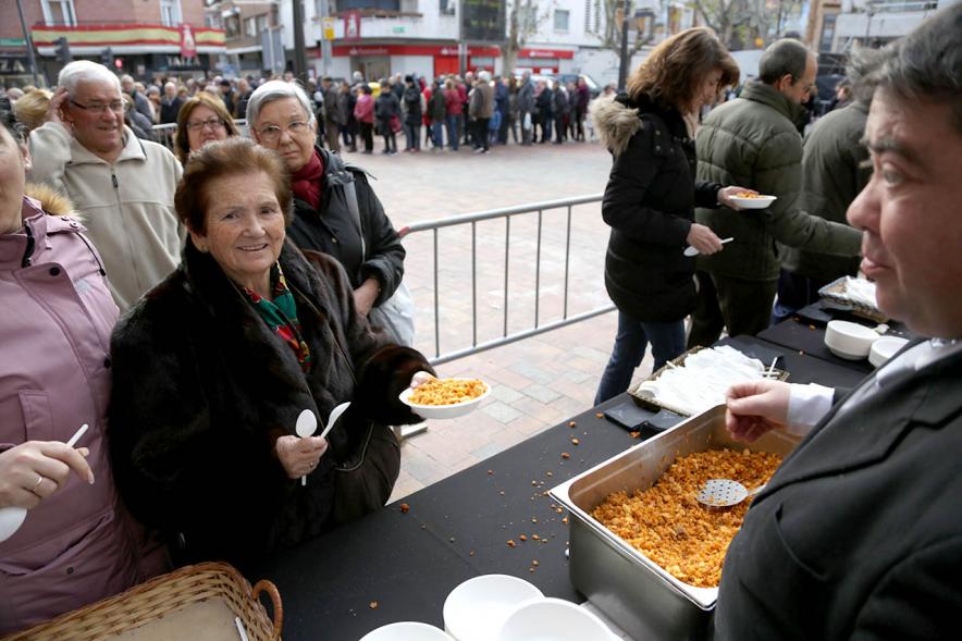 Fiestas Virgen de la Paz 2019 - Degustación de Migas y Gachas - Primer plano del reparto de las migas a los vecinos.