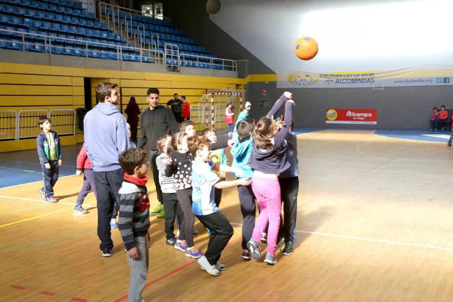 Día Multideportivo por la Integración y la Conciliación -  Imagen de un grupo de niño jugando al balonmano con sus monitores.