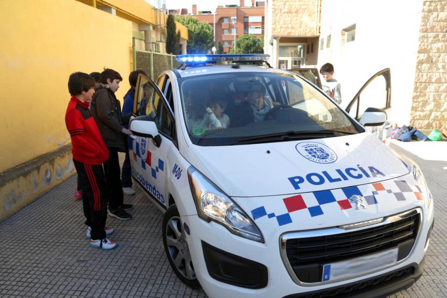 Día Multideportivo por la Integración y la Conciliación - Imagen  de los niños  curioseando  un coche de policia.