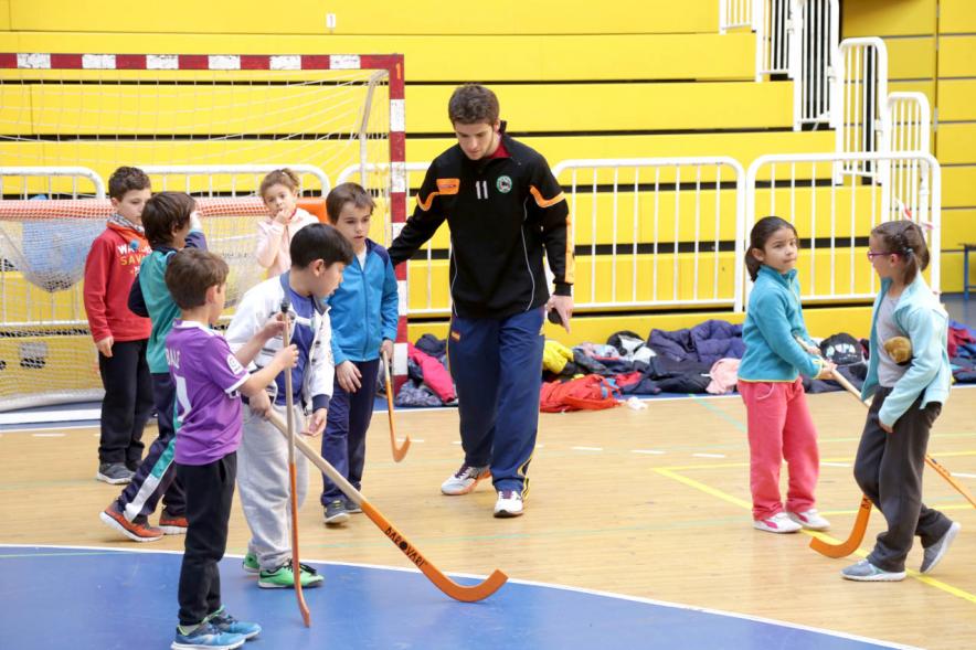 Día Multideportivo por la Integración y la Conciliación -  Imagen  de los niños  preparándose para jugar al hockey con un monitor.