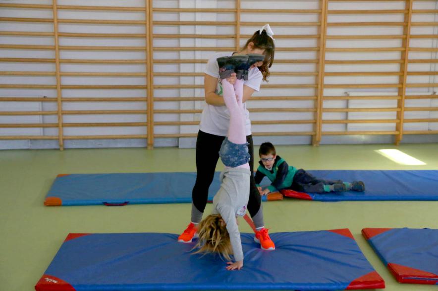 Día Multideportivo por la Integración y la Conciliación - Imagen de los niños  haciendo gimnasia sobre una colchoneta.