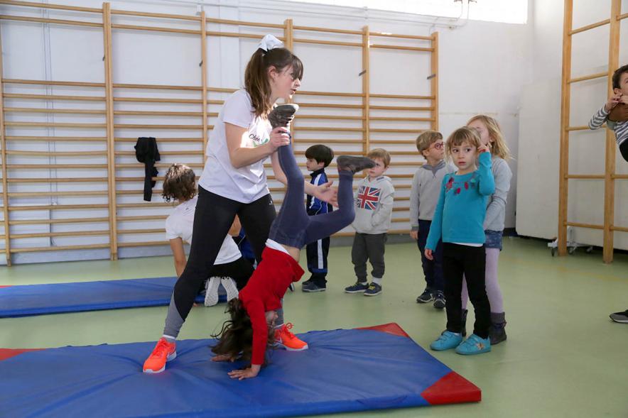 Día Multideportivo por la Integración y la Conciliación - Imagen de una niña haciendo el pino con su monitora.