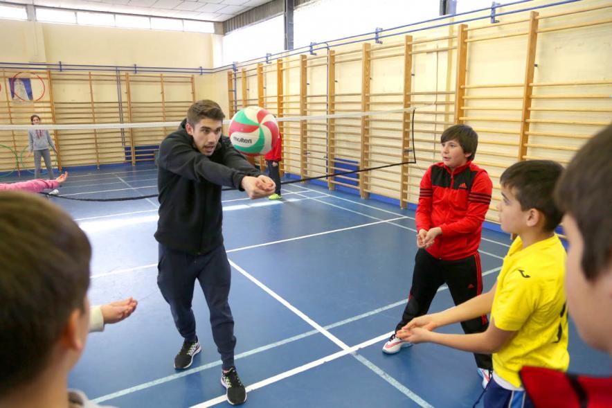 Día Multideportivo por la Integración y la Conciliación - Primer plano del monitor enseñando a jugar al voley.