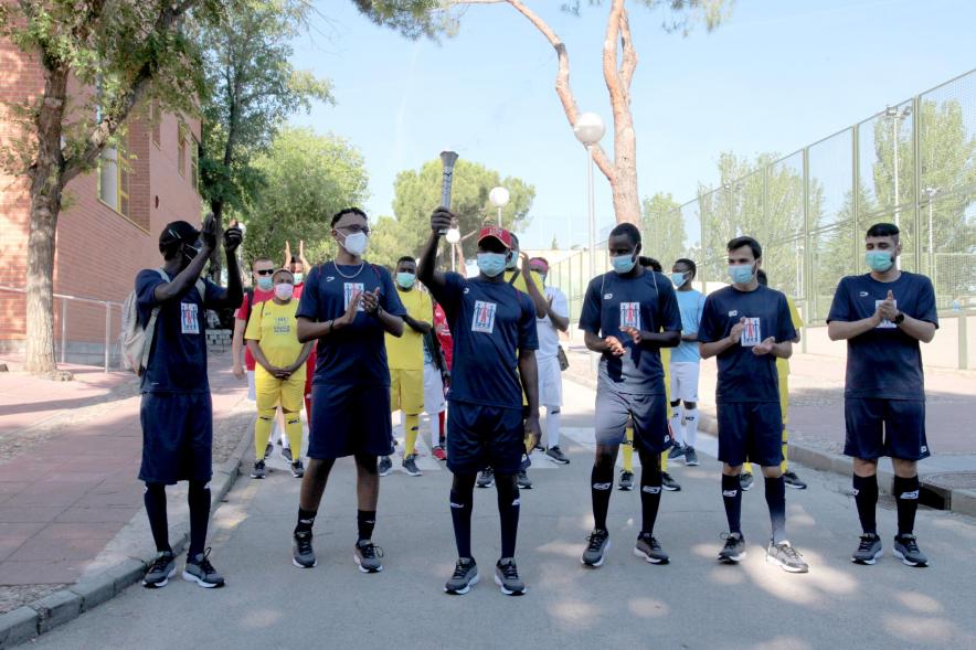 Jornada Inclusiva Día Mundial del Refugiado -Imagen de la entrada de la antorcha de manos de algunos de los participantes en la jornada.