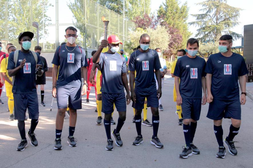 Jornada Inclusiva Día Mundial del Refugiado -Imagen de la entrada de la antorcha de manos de algunos de los participantes en la jornada.