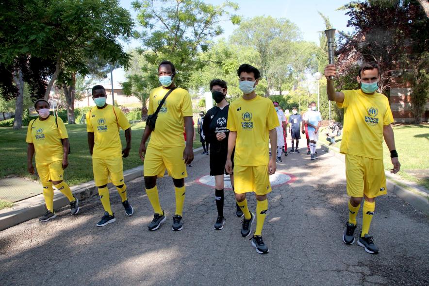 Jornada Inclusiva Día Mundial del Refugiado -Imagen de la entrada de la antorcha de manos de algunos de los participantes en la jornada.