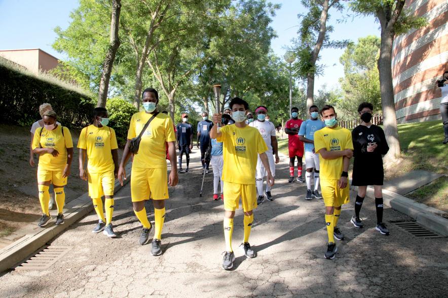 Jornada Inclusiva Día Mundial del Refugiado - Imagen de la entrada de la antorcha de manos de algunos de los participantes en la jornada.
