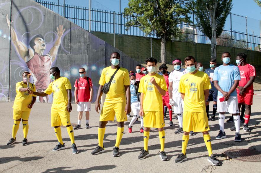 Jornada Inclusiva Día Mundial del Refugiado -Imagen de la entrada de la antorcha de manos de algunos de los participantes en la jornada.