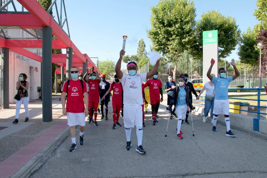 Jornada Inclusiva Día Mundial del Refugiado -Imagen de la entrada de la antorcha de manos de algunos de los participantes en la jornada.