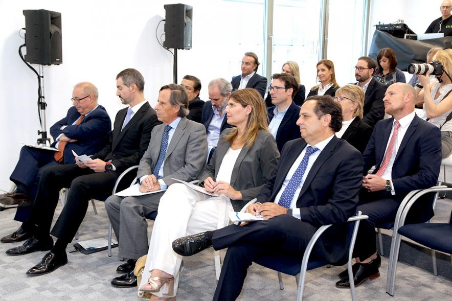 Inauguración Nueva Sede Domino - Imagen del alcalde García de Vinuesa y otras personalidades en sus sillas en la sala escuchando una intervención.