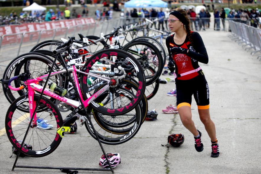 Duatlón Villa de Alcobendas 2017 - Imagen de una  corredora en el momento de coger la bicicleta para seguir con la carrera de bici.