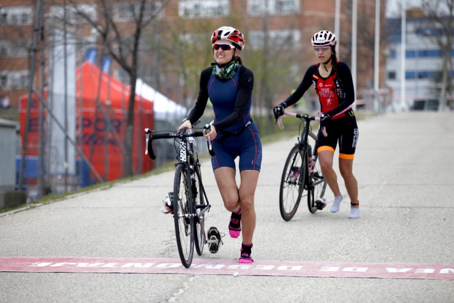 Duatlón Villa de Alcobendas 2017 - Imagen de unas corredoras en el momento de coger la bicicleta para seguir con la carrera de bici.