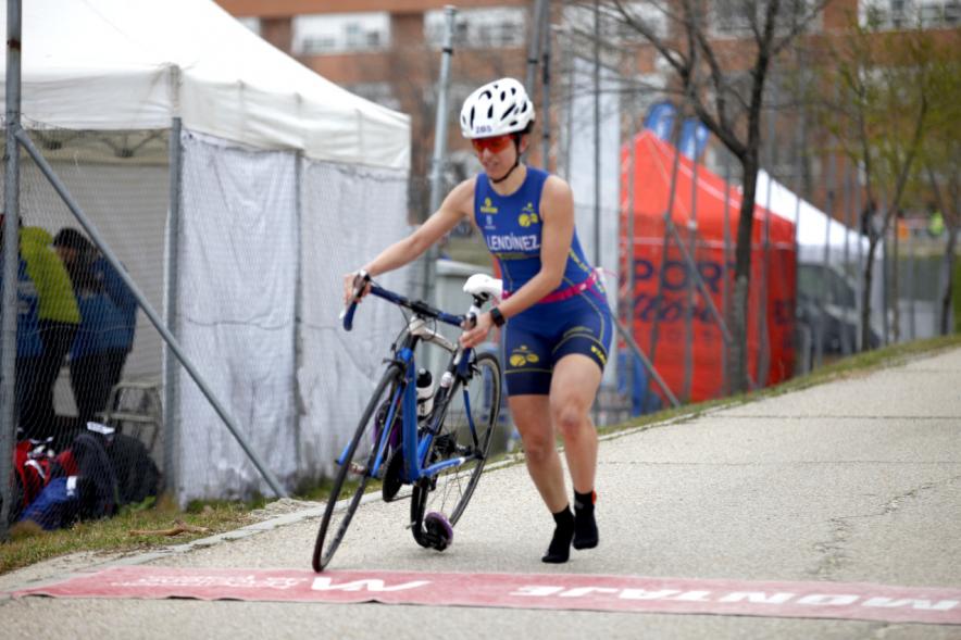 Duatlón Villa de Alcobendas 2017 -  Imagen de una  corredora en el momento de coger la bicicleta para seguir con la carrera de bici.