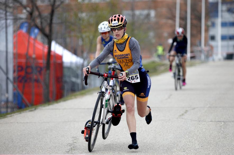 Duatlón Villa de Alcobendas 2017 - Imagen de una  corredora en el momento de coger la bicicleta para seguir con la carrera de bici.