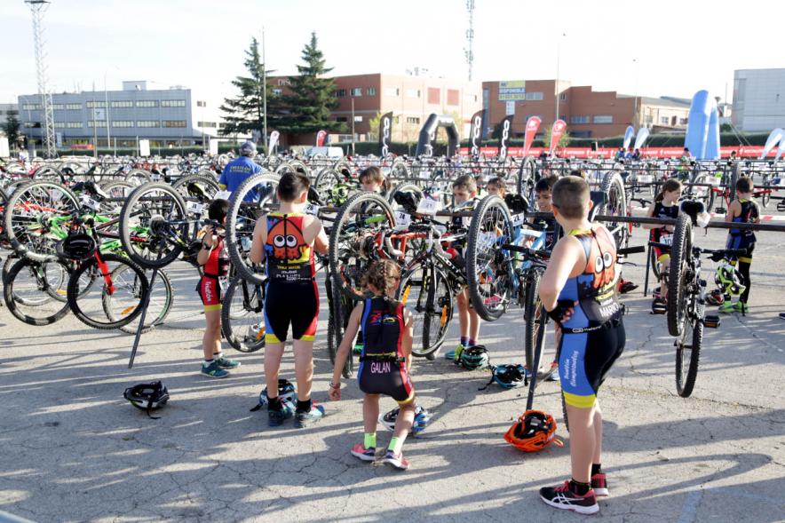 Duatlón Escolar Villa de Alcobendas - Imagen de un  grupo de deportistas revisando las bicicletas.