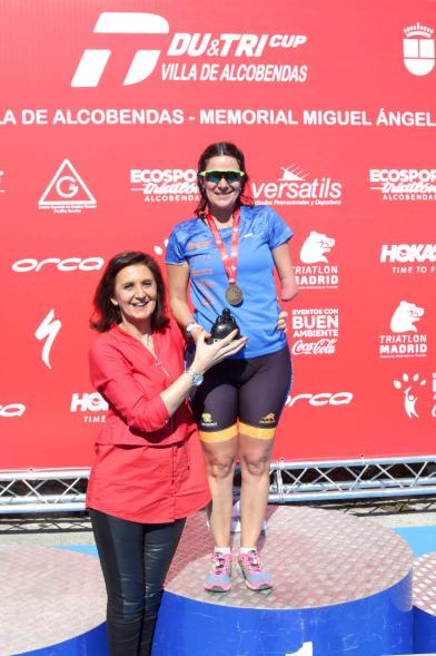 Entrega Premios Campeonato Comunidad de Madrid de Duatlón - Imagen de la concejala de deportes Mar Rodríguez haciendo entrega de su premio a una deportista con discapacidad.
